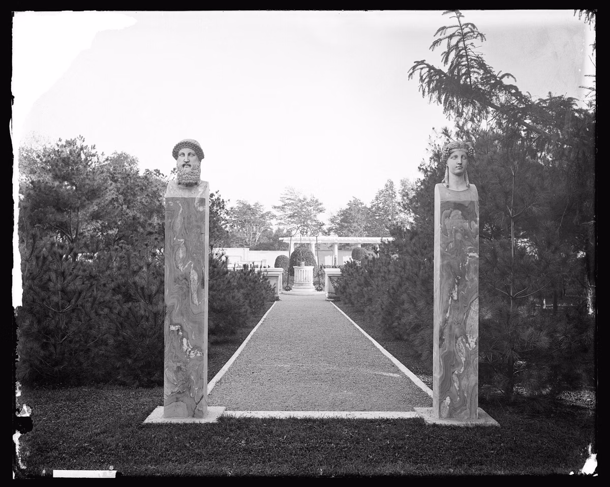 A path between two tall stone piers leading to the Italian garden at Weld, the Anderson estate in Brookline, in an early glass-plate photograph