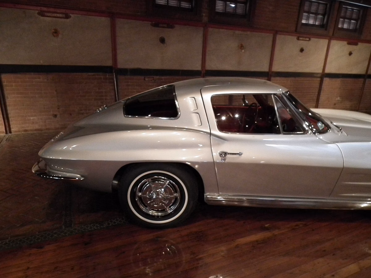 A silver 1963 Corvette Sting Ray split-window coupe on the wooden floor of the Larz Anderson Auto Museum