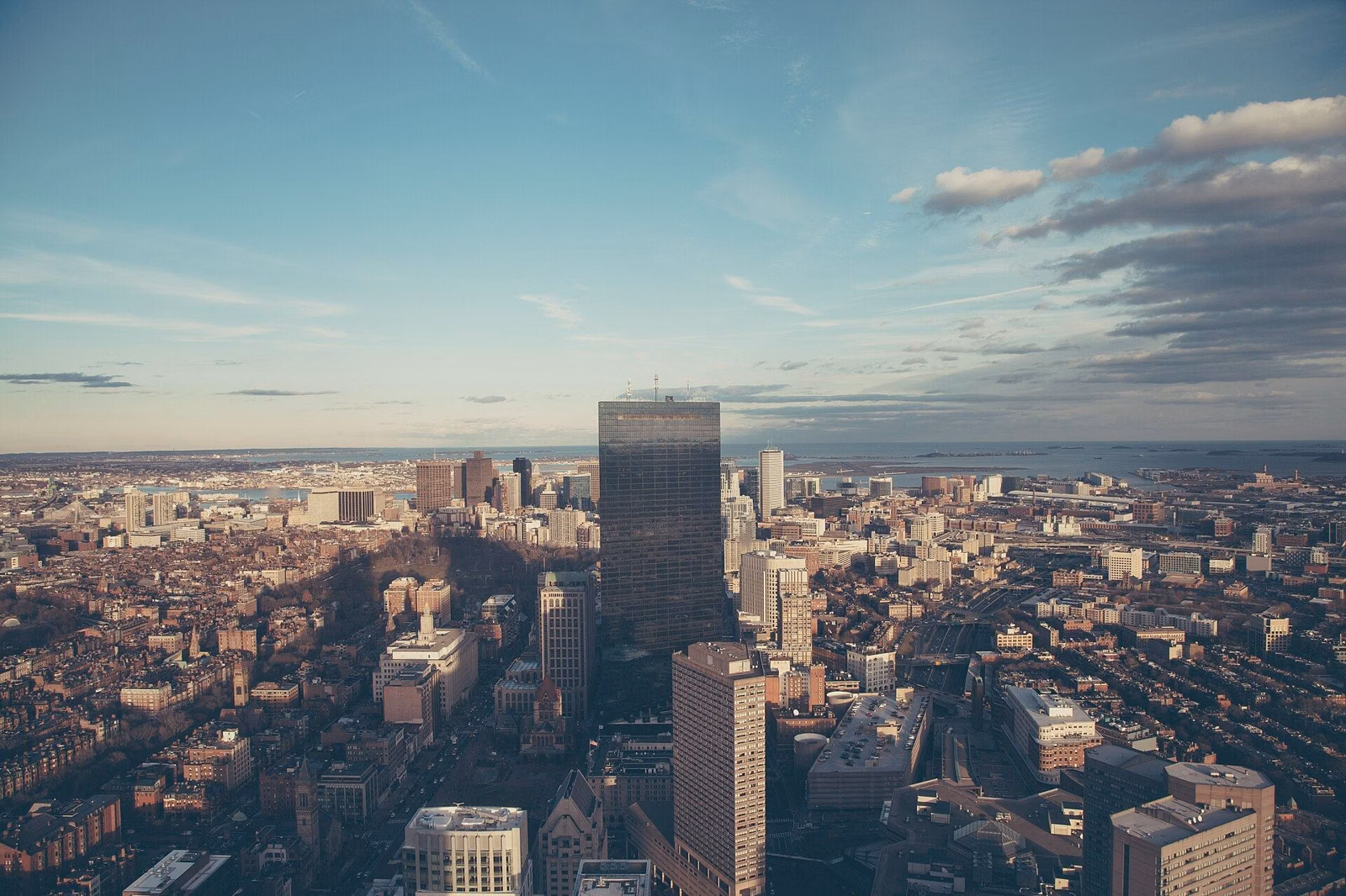 A wide view over a city's rooftops and towers at golden hour