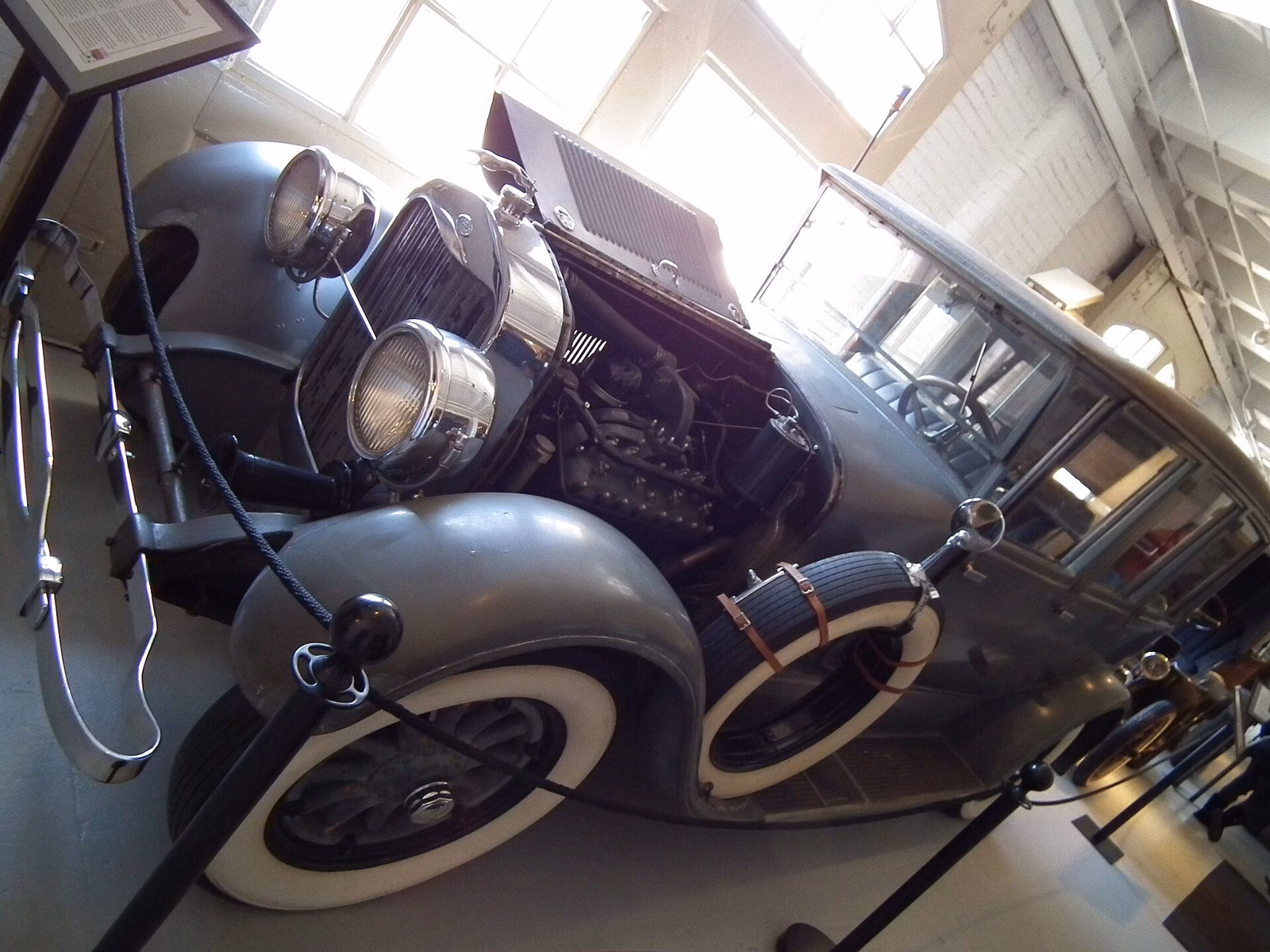 Big chrome headlights and the fender of a vintage car inside the Larz Anderson Auto Museum