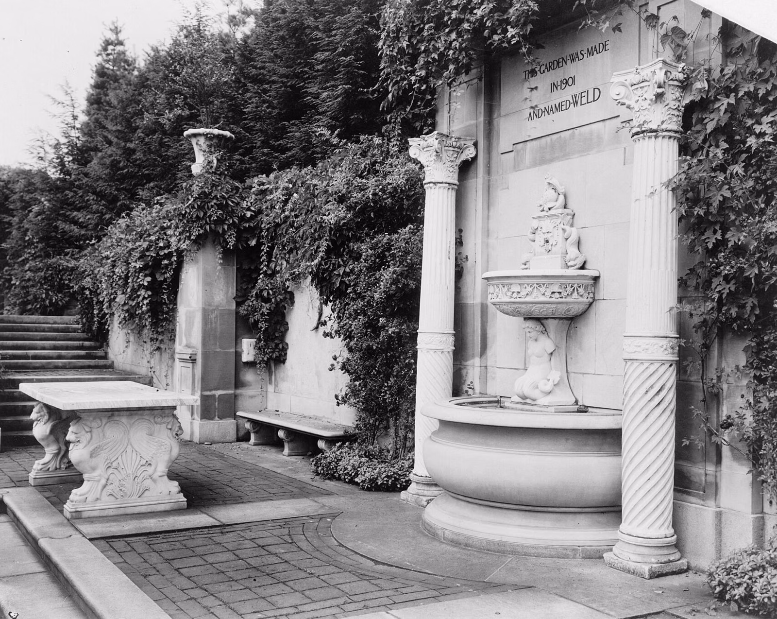 A wall fountain and stone bench on the terrace of the Anderson estate's Italian Garden, about 1914